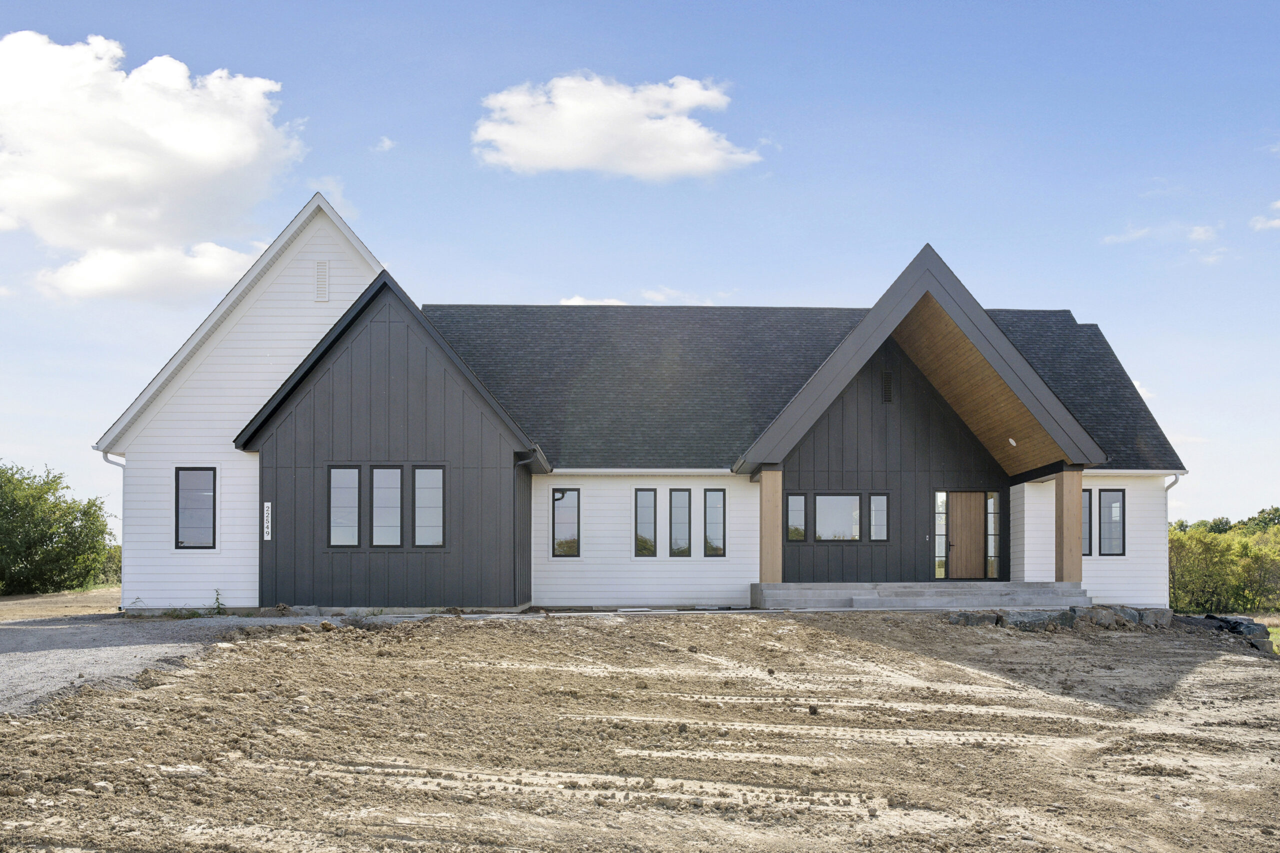 White and black modern farmhouse exterior with steep gables — The Pristine