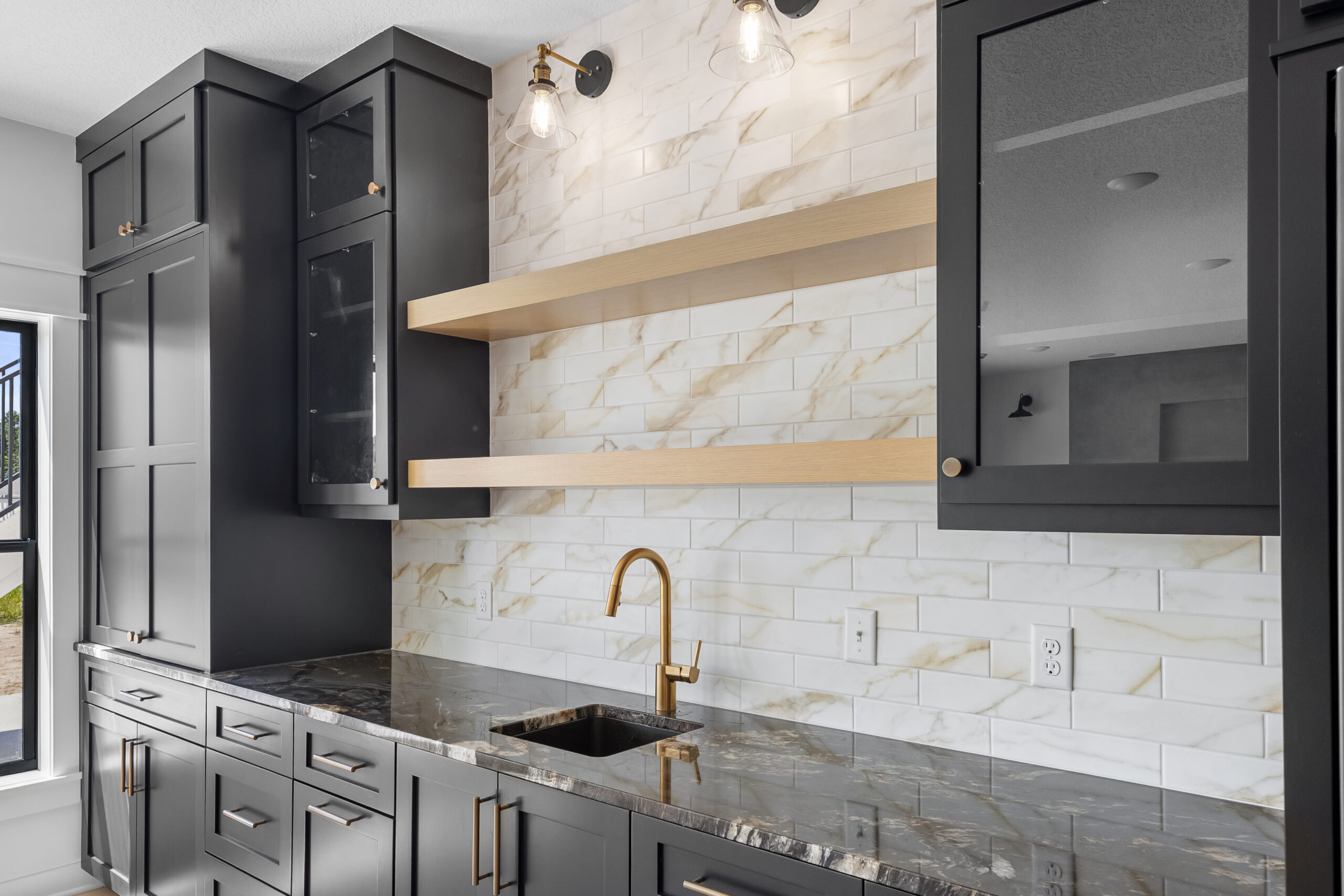 The Summit — chef's kitchen with marble backsplash and brass fixtures